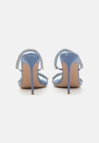 Blue high-heeled sandals with clear straps, embellished with silver beaded accents. Smooth texture with a pointed toe and stiletto heel.