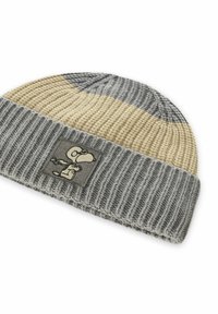 Grijze en beige gebreide beanie met geribbelde textuur en een rechthoekige patch met een karakterontwerp. Zacht, warm materiaal.
