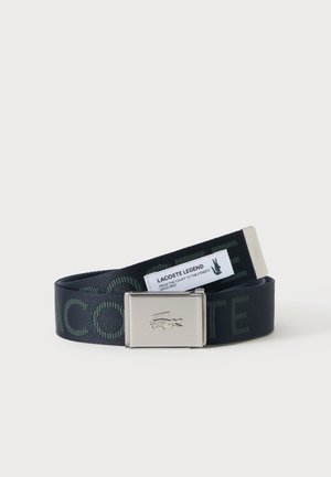Sort stofbælte med mørkegrøn tekst og en sølvspænde præget med en krokodillelogo, mærket Lacoste Legend.