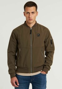 Giacca bomber verde oliva realizzata in tessuto testurizzato, con zip centrale, tasche laterali, polsini a costine e un piccolo logo sul petto.