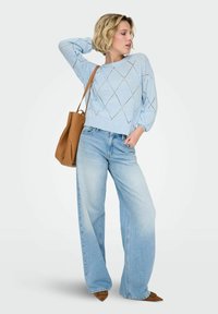 Pull bleu clair en maille avec un motif en losange, associé à un jean ample bleu clair et un sac cabas marron. Des chaussures marron pointues complètent le look.
