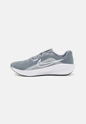 Gray athletic shoes featuring a breathable mesh upper, white swoosh logo, thick white midsole, and a textured black rubber sole.