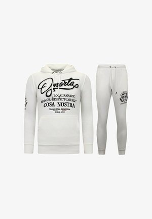 Witte hoodie en bijpassende joggers, met zwarte tekst en graphics. Het materiaal lijkt zacht met ribgebreide manchetten en een tailleband.