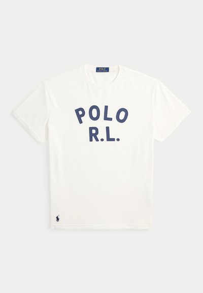 Λευκό T-shirt με στρογγυλή λαιμόκοψη και μπλε σκούρα γράμματα "POLO R.L." στο στήθος και μικρό λογότυπο παίκτη πόλο σε μπλε σκούρο κοντά στο κάτω μέρος.