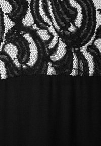 Tissu noir avec une superposition de dentelle florale, présentant un motif en maille complexe et des détails de fils noirs tourbillonnants.