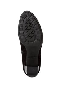 Stivaletto in suede nero con suola in gomma testurizzata e grip a motivo. Include un tacco basso e tomaia in morbido tessuto.