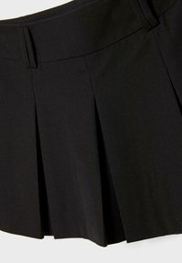 Schwarzer plissierter Rock mit flachem Bund, aus glattem Stoff gefertigt. Mit scharfen, definierten Falten für einen strukturierten Look.