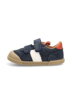 Zapato para niño pequeño en azul marino con suela beige, franjas laterales blancas, dos tiras de Velcro y una pestaña en el talón naranja, mostrado desde el lado exterior.