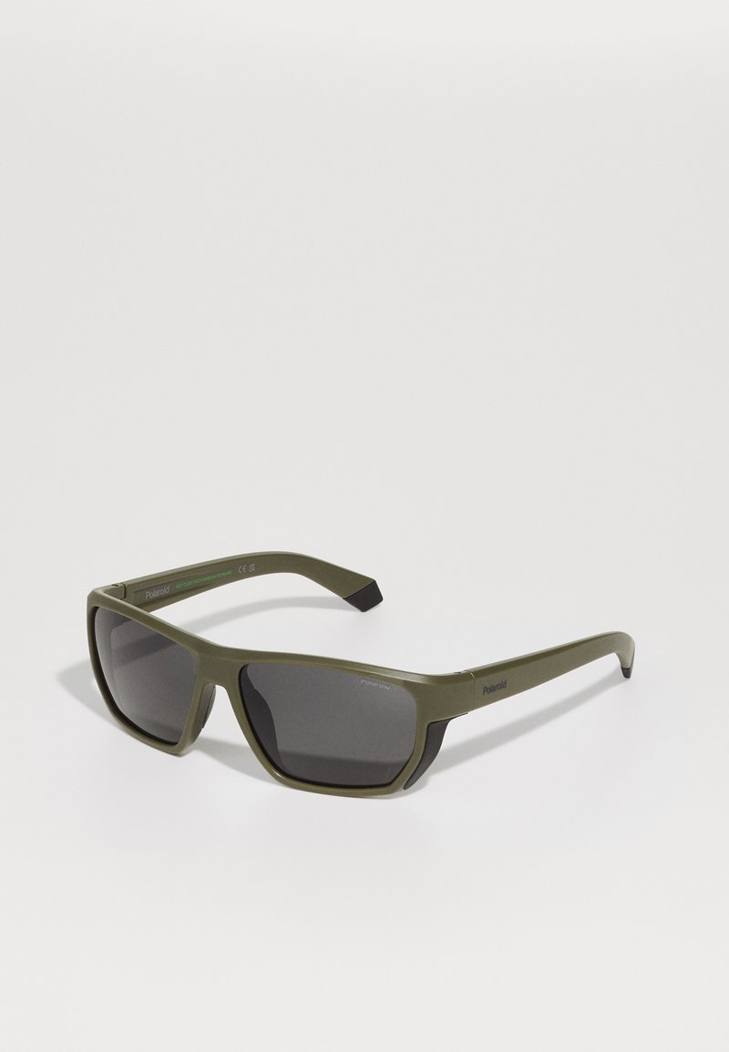 Green plastic sunglasses with gray lenses, angular frame, and a matte finish. Features the brand name "Polaroid" on the temple.