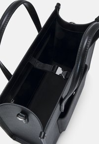 Black synthetic tote bag with textured finish. Interior features a large compartment, zipper pocket, and adjustable strap with clasp.