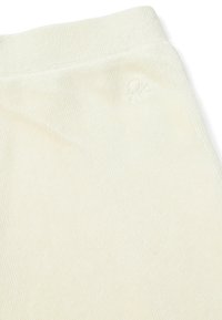 Kremowa aksamitna tkanina z lekkim połyskiem, z teksturowanym prążkowanym wzorem i wytłoczonym logo blisko pasa.