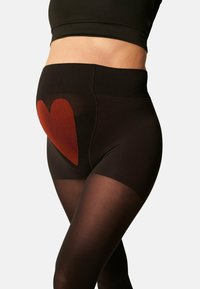 Collant per maternità neri con sovrapposizione trasparente, caratterizzati da un importante motivo a cuori rosse nella parte anteriore bassa. Tessuto morbido, design a vita alta.
