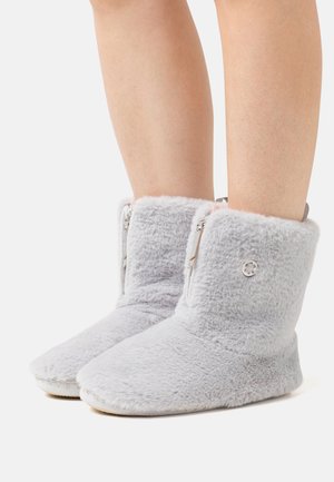 Gray faux fur ankle boots with a soft texture, featuring a zip closure on the side and a round logo accent. Flat, non-slip sole.