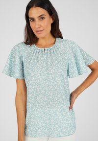 Lichtblauwe bloemenblouse met korte fladdermouwen, gepleatste halslijn en een sleutelgatdetail. Zachte stof en een relaxte pasvorm.