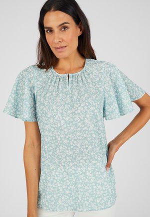 Blusa floral de color azul claro con mangas cortas tipo aleteo, escote plisado y detalle de ojal. Tejido suave y corte relajado.