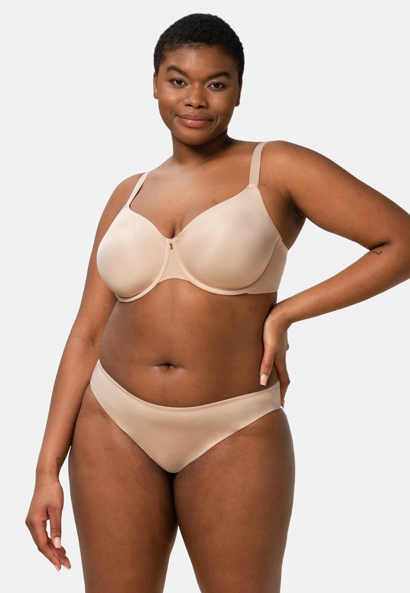 Sous-vêtements nude avec une texture lisse, un design à bonnets moulés et des bretelles réglables. Le soutien-gorge comporte un accent zippé au centre avant.