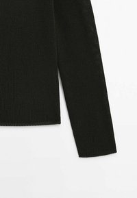 Manche de pull en maille noire à manches longues et partie du torse sur fond blanc, montrant une texture côtelée et un ourlet droit.