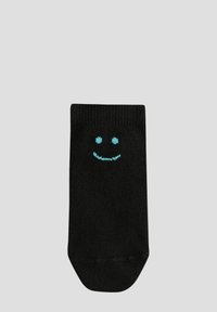 Chaussette en coton noir avec une texture côtelée et un design de visage souriant turquoise à l'avant. Longueur courte jusqu'à la cheville avec un bout arrondi.