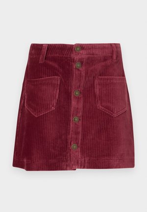 Gonna mini in corduroy di un rosso intenso, con chiusura frontale a bottoni, due tasche frontali applicate e passanti per la cintura.