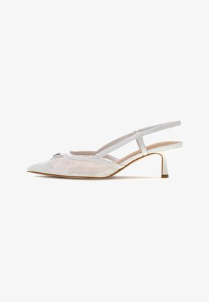 Chaussure slingback blanche à bout pointu avec superposition en dentelle, petit talon kitten et boucle décorative à l'avant.