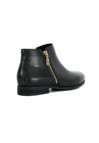 Bottines en cuir noir avec un talon texturé, fermeture éclair latérale dorée, bout arrondi et un talon empilé bas. Surface lisse et à motifs.