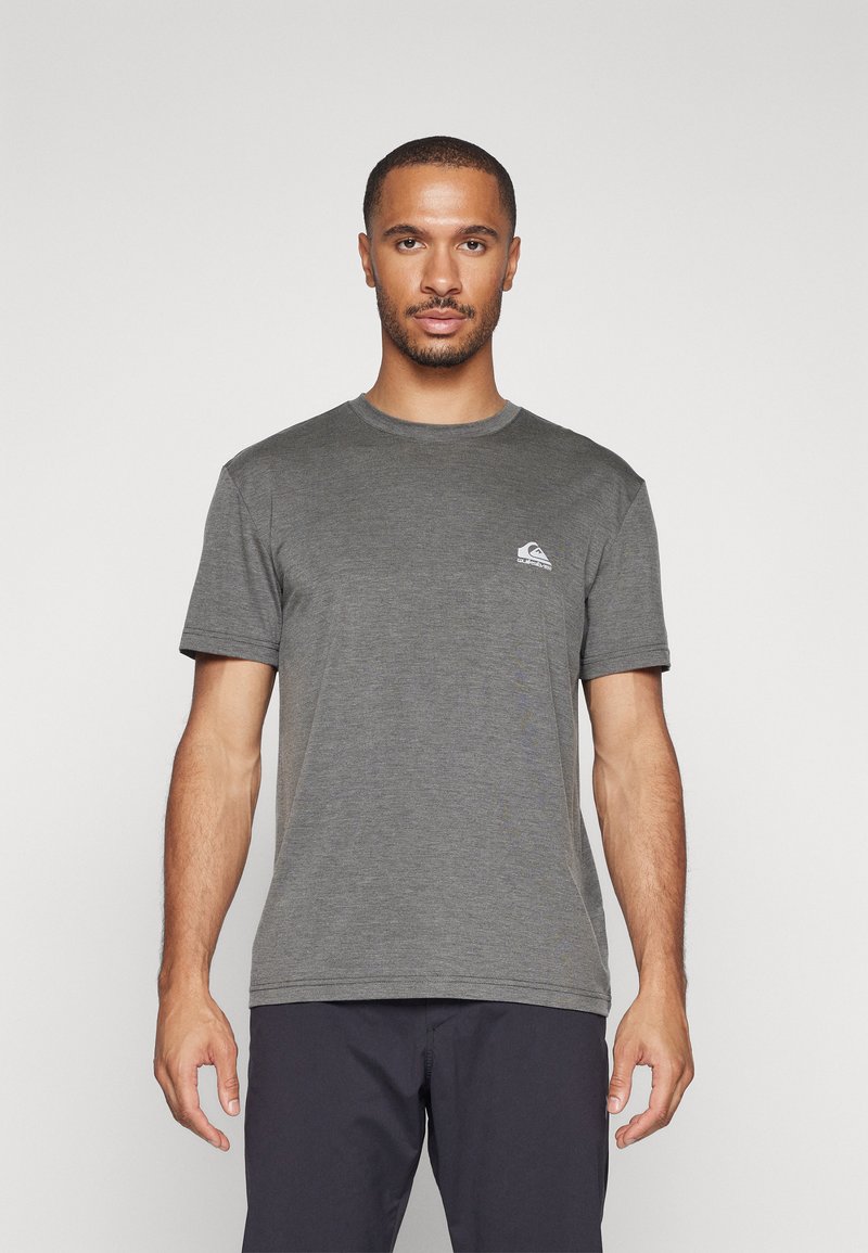 Camiseta gris de manga corta hecha de una tela suave, con un pequeño logo en el lado izquierdo del pecho. Cuello redondo clásico y corte regular.