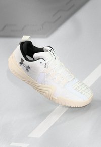 Weiße Sportschuhe mit einer strukturierten Oberseite, kontrastierendes schwarzes Innenfutter und einer cremefarbenen Sohle. Enthält Mesh- und Gummidetails.