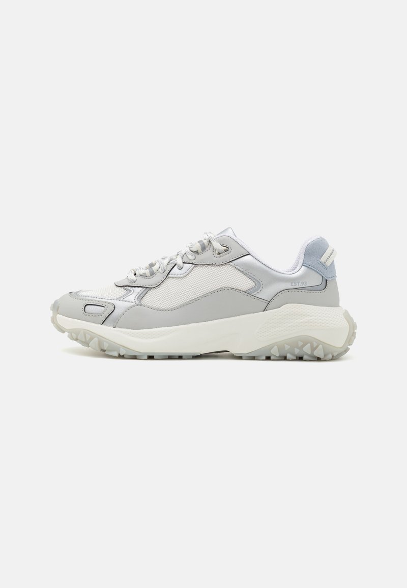 Baskets de sport gris clair et blanches avec semelle texturée, panneaux en mesh et cuir, fermeture à lacets et col de talon rembourré.