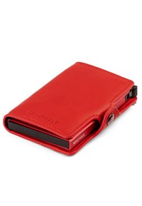 Compact red leather wallet with button closure, embossed "MONEYHOLD" branding, and black card holder section visible on the side.