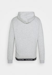 Grijze hoodie met een capuchon met trekkoord, geribbelde manchetten en een zwarte elastische tailleband met de tekst "CLOSURE". Gladweefsel textuur.