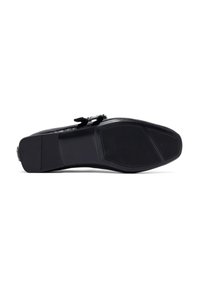 Scarpa in pelle nera con punta arrotondata, upper testurizzato e suola piatta con un motivo di grip in gomma. Decorata con un fiocco decorativo.