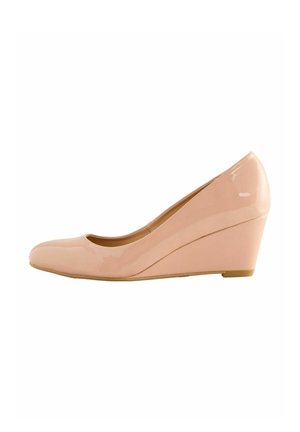 Zapato de tacón cuña en material sintético brillante de color rosa claro, con puntera redonda y diseño suave, que presenta un tacón de altura moderada.