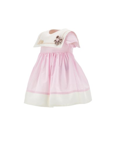 Vestito rosa per bambina con colletto da marinaio bianco, vita arricciata, bordatura color crema e fiore decorativo in tessuto sul colletto.