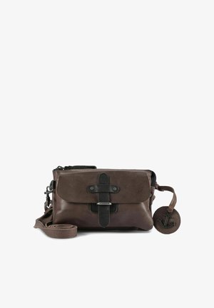 Bruine leren crossbodytas met zwarte accenten, een voorklep die wordt vastgehouden door een riem, ritssluiting en een ronde hanger met een ankerontwerp.