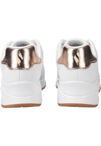 Scarpe da ginnastica bianche con una finitura testurizzata, caratterizzate da un accento sul tallone in rosa oro metallico e un suola in gomma color cuoio.