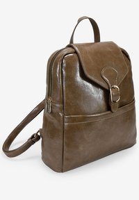 Mochila de imitación cuero marrón con cierre de solapa, una hebilla decorativa, bolsillo lateral con cremallera y un asa superior para llevar.