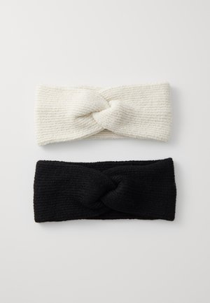 Deux bandeaux noués : l'un en tricot côtelé crème, l'autre en tricot côtelé noir uni. Les deux présentent un tissu texturé et un design large.