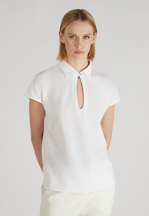 Biała blouse z krótkim rękawem, z kołnierzykiem i otworem w kształcie łezki z przodu, charakteryzująca się subtelnym połyskiem i czystymi liniami.