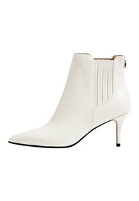 Bottine en cuir blanc avec un bout pointu, un talon aiguille fin et un design côtelé vertical sur le côté pour un relief supplémentaire.