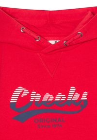 Red hoodie featuring a drawstring hood, ribbed collar, and printed graphic with "Crooks" in striped white and navy, and "ORIGINAL Since 1974" text.