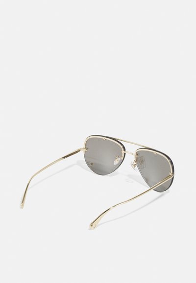 Sunglasses with gray lenses, a thin gold metal frame, and elongated wire arms. Features small decorative elements on the frame.