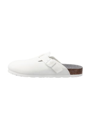 Weißer Slip-On Clog mit Obermaterial aus Stoff, verstellbarem Riemen mit Schnalle, Korkfußbett und weißer strukturierter Sohle.
