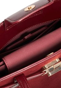 Burgundy leather handbag featuring a gold clasp, smooth exterior, and suede lining, with multiple interior compartments for organization.