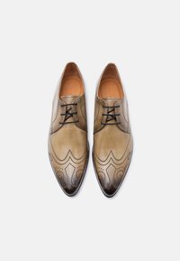 Δερμάτινα παπούτσια φόρμας σε βαθμιαία καφέ απόχρωση, με διακοσμητικές τρύπες (brogue), μυτερή μύτη και μαύρα κορδόνια. Ομαλή υφή με γυαλιστερές λεπτομέρειες.