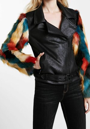 Veste en cuir synthétique noir avec des manches en fausse fourrure colorées en rouge, bleu et jaune. Présente une taille ceinturée et des poches zippées.