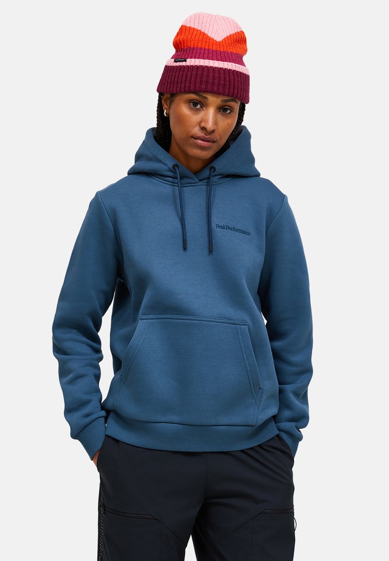 Blauer Kapuzenpullover mit Kängurutasche und Kordelzug. Der Text "PeakPerformance" ist auf der Brust gestickt. Schlichtes, tailliertes Design.