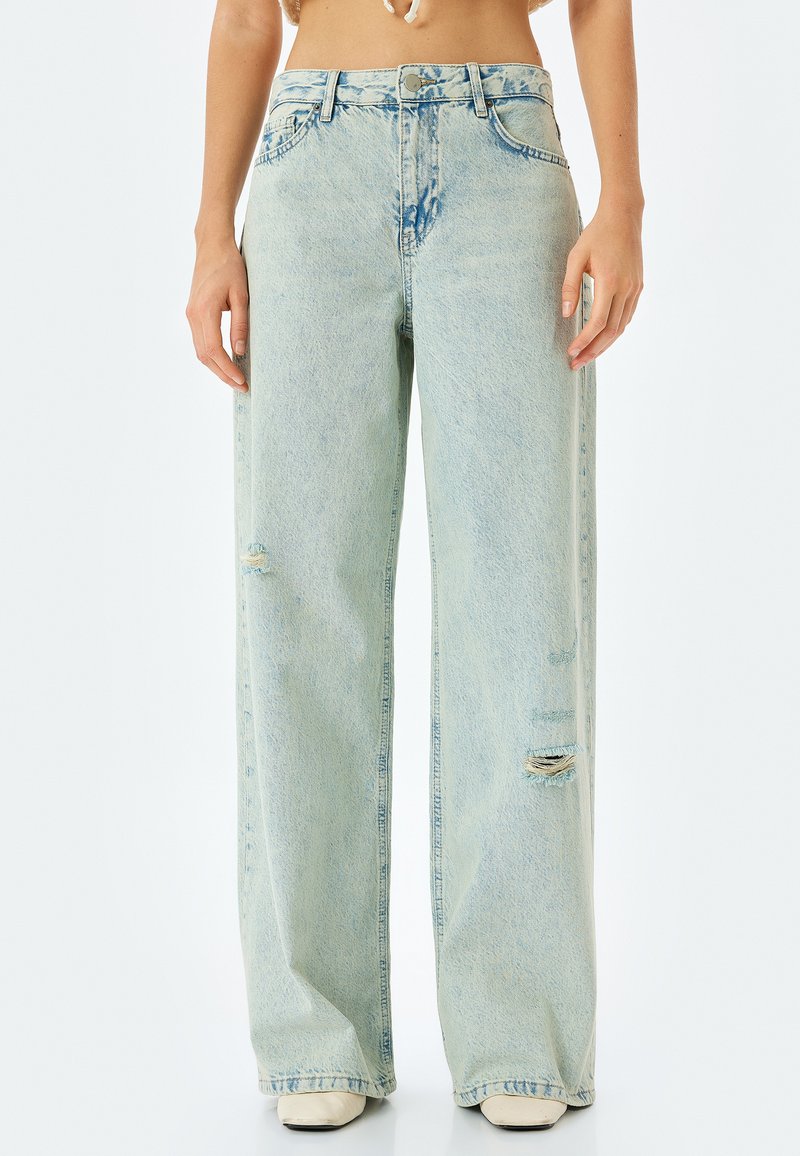 Ljust tvättade, vida jeans i denim. Har slitna detaljer och hög midja. Rakt snitt och fransade fållar.