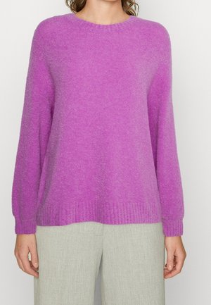 Pullover viola a maniche lunghe con scollatura rotonda, realizzato in un tessuto morbido. Presenta orlo e polsini a costine, abbinato a pantaloni grigi chiari.