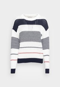 Pull en maille blanche avec rayures horizontales bleu marine et rouges, col rond et manches longues sur fond gris clair.