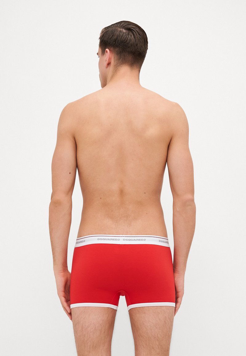 Caleçons boxers rouges avec une bande blanche comportant le logo "DSQUARED2", coupe ajustée, texture lisse et bord blanc contrastant le long des jambes.